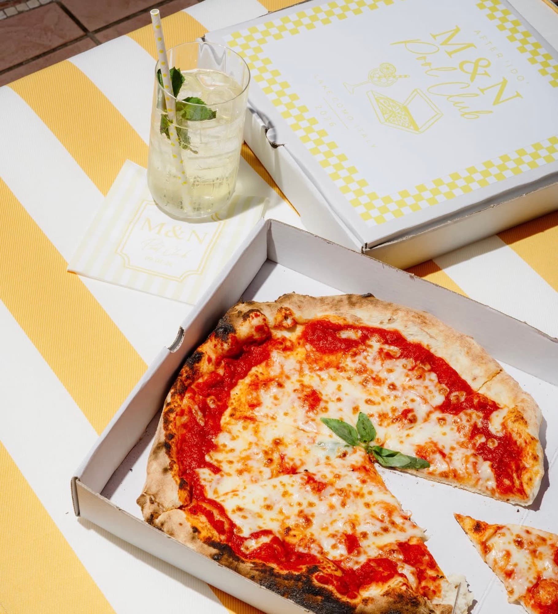 Pizza margherita napoletana in scatola con drink a un evento sul lago