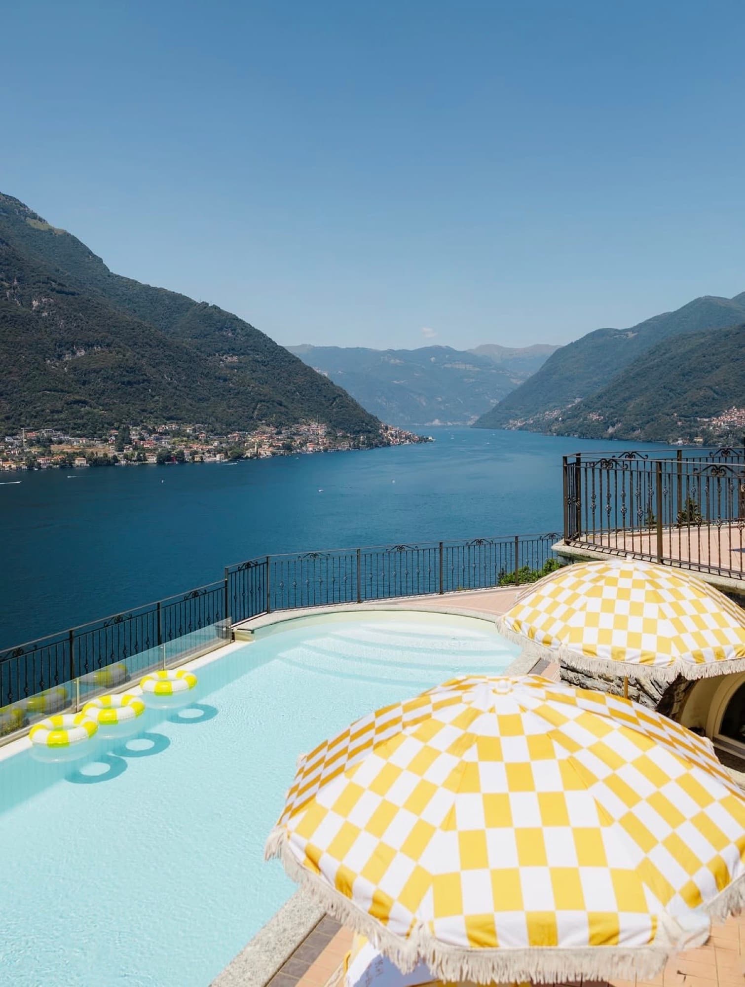 Piscina panoramica sul Lago di Como con ombrelloni gialli