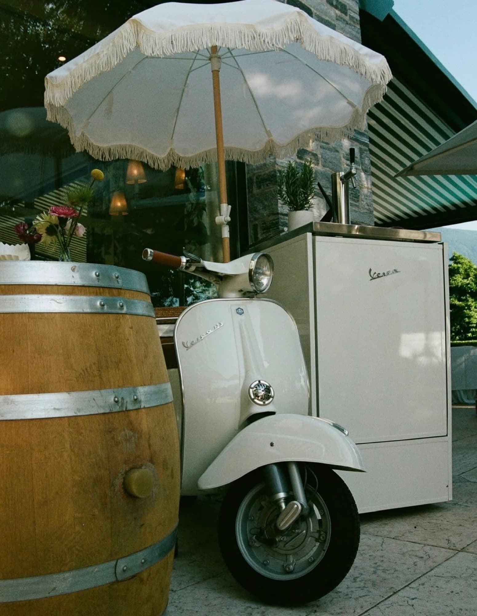 Vespa bar vintage bianca con botte di vino all'evento