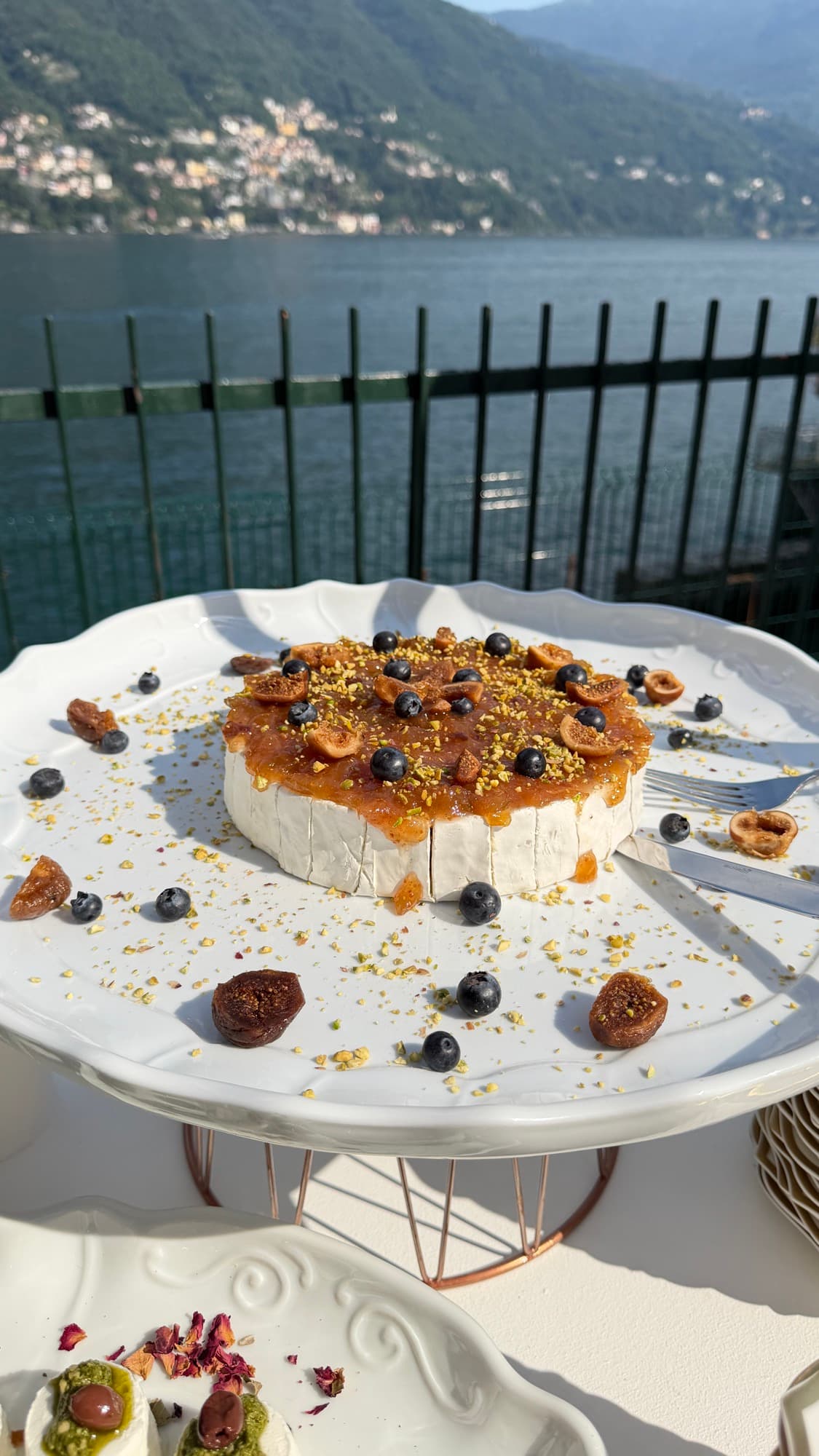 Ruota di formaggio con fichi, mirtilli e pistacchi vista lago
