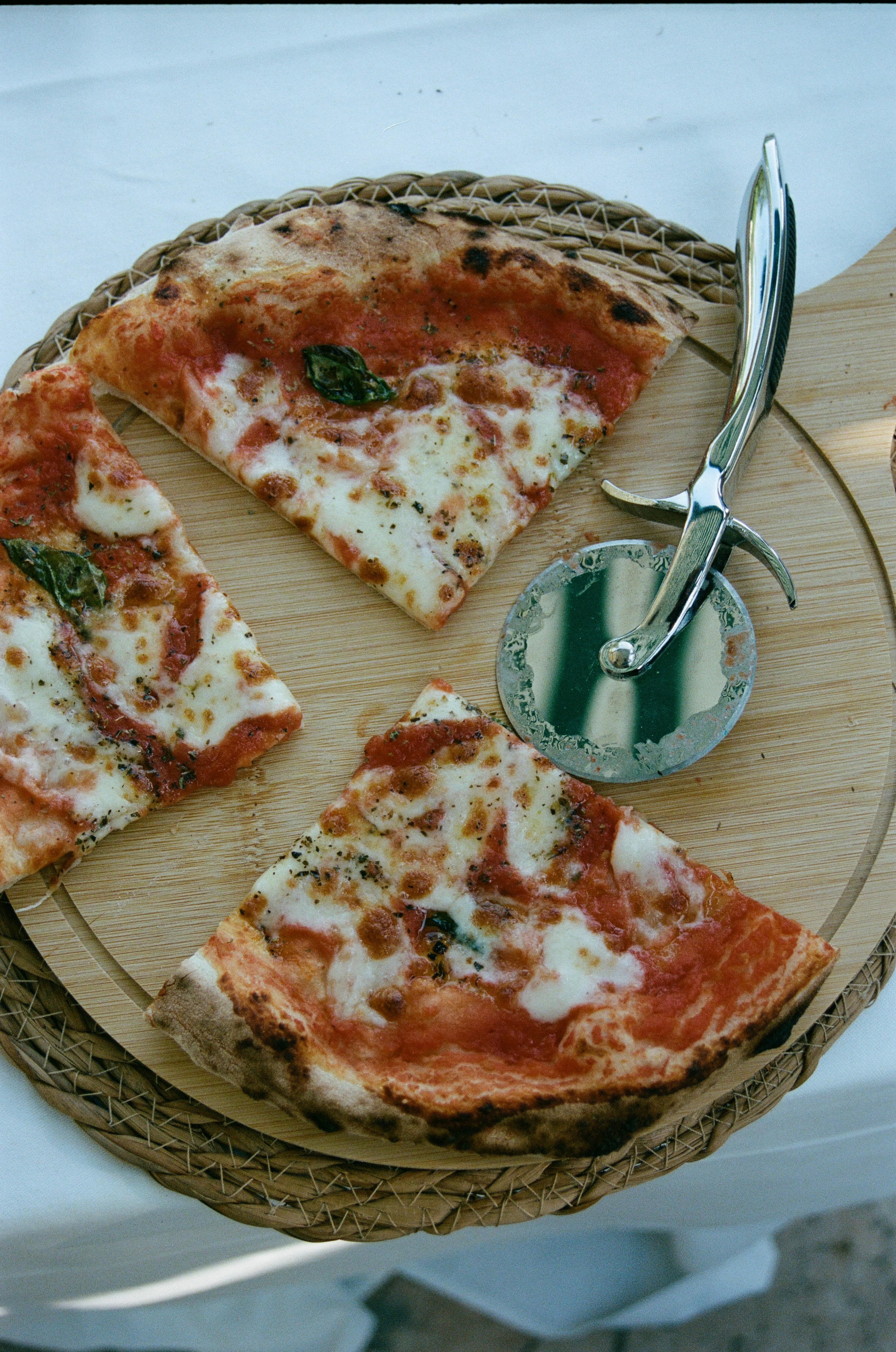 Pizza margherita napoletana tagliata su tagliere in legno