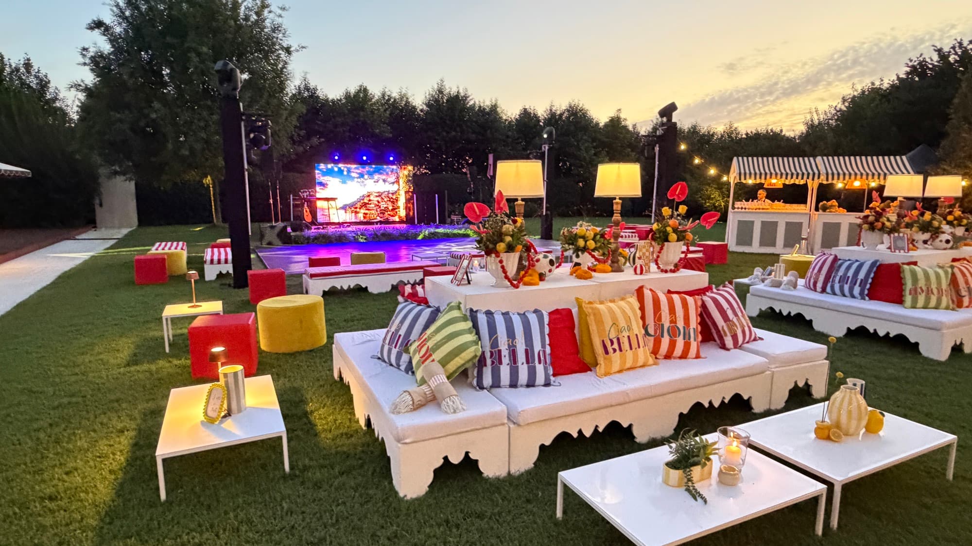 Lounge con divani e cuscini a righe davanti al palco in giardino, Serata Italiana