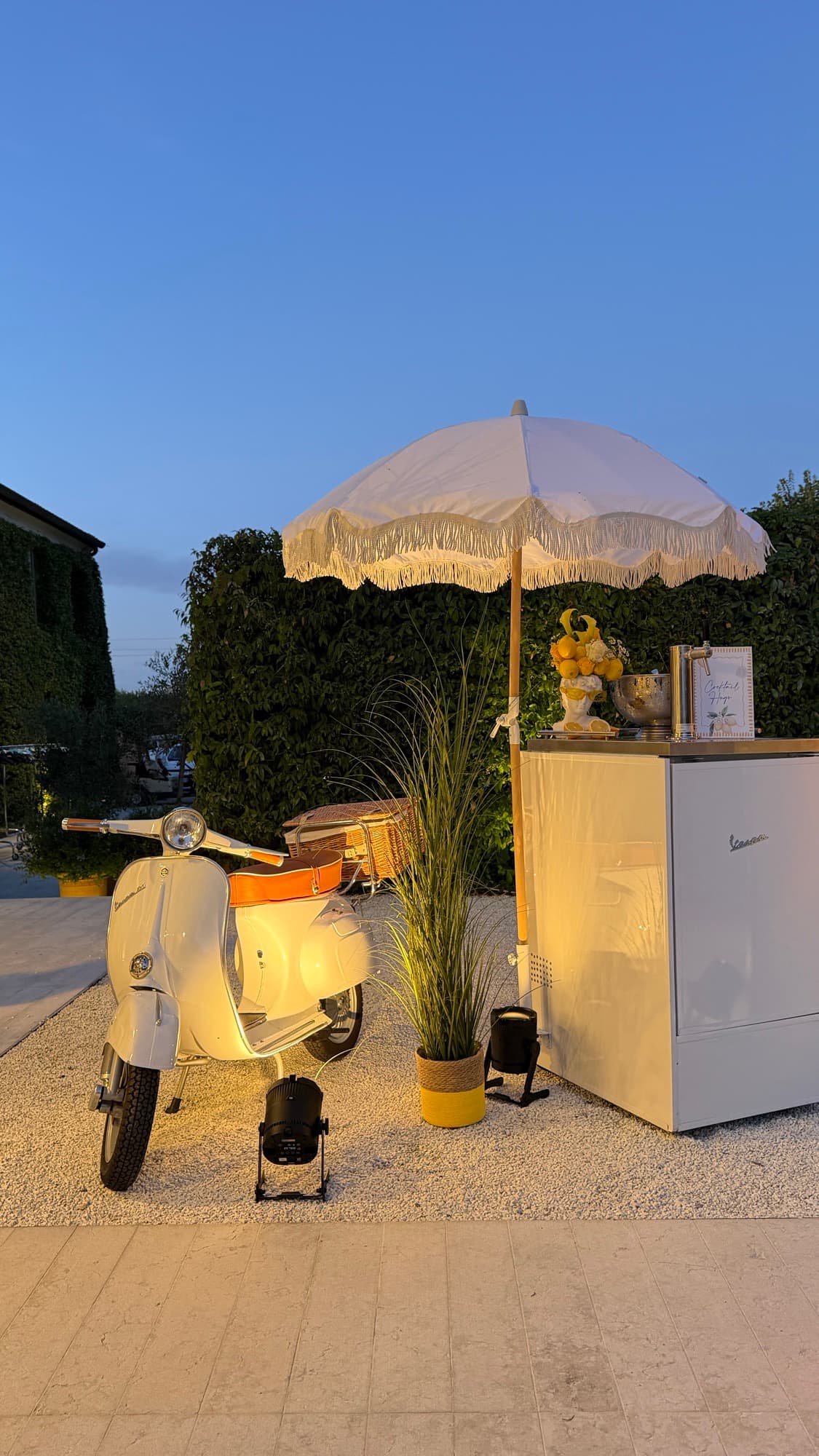 Vespa bar d'epoca con ombrellone e banco bar all'ora blu