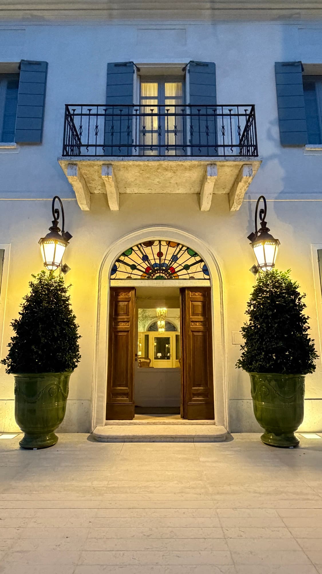 Ingresso della villa illuminato con lanterne e piante in vaso